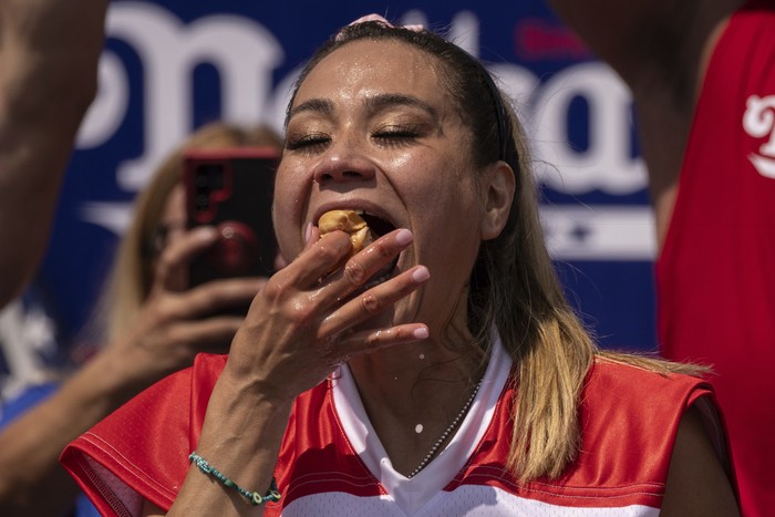 Competitive eaters eat hot dogs during the 2023 Nathans Famous Fourth of July hot dog eating contest in the Coney Island section of the Brooklyn borough of New York, Tuesday, July. 4, 2023. (AP Photo/Yuki Iwamura)
