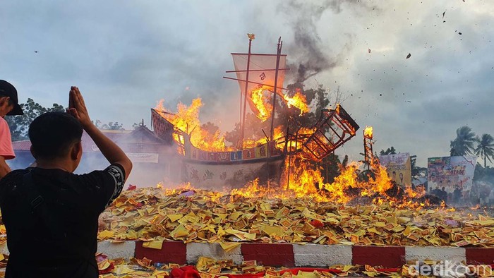 Puluhan ribu wisatawan lokal dan mancanegara hari ini ikut merayakan tradisi Bakar Tongkang di Rokan Hilir, Riau, Selasa (4/7/2023). Kali ini, kapal tongkang yang terbakar jatuh ke arah laut.