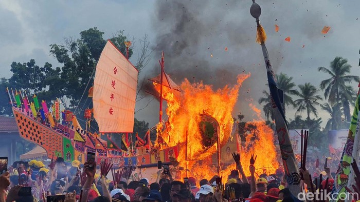 Puluhan ribu wisatawan lokal dan mancanegara hari ini ikut merayakan tradisi Bakar Tongkang di Rokan Hilir, Riau, Selasa (4/7/2023). Kali ini, kapal tongkang yang terbakar jatuh ke arah laut.