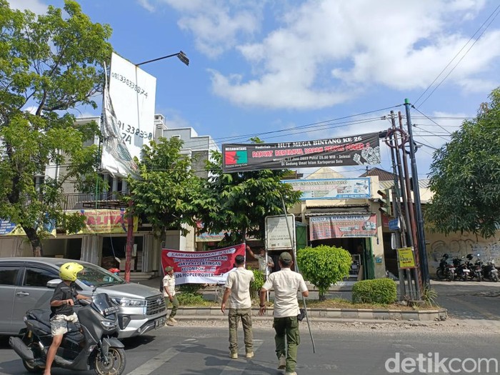 Satpol PP Kota Solo mencopoti spanduk penolakan aksi people power di jalanan, Rabu (5/7/2023).
