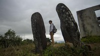 Seorang pengunjung berpose di lokasi situs.