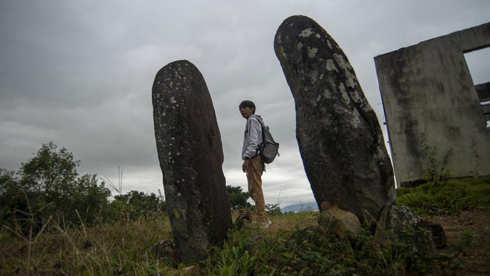 Pengunjung melintas di kompleks situs menhir Nagari Simawang, Tanah Datar, Sumatera Barat, Rabu (5/7/2023). Situs cagar budaya megalit kompleks makam kuno yang diperkirakan berasal dari sekitar awal abad ke XVIII itu kini kondisinya terbengkalai. ANTARA FOTO/Iggoy el Fitra/foc.