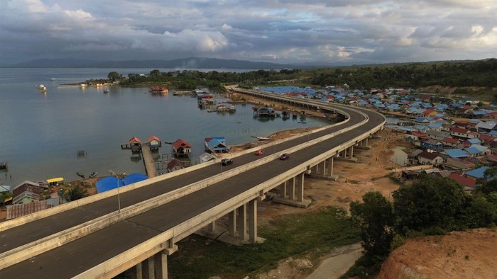 Foto udara beberapa kendaraan melintas di atas jembatan antara Kota Kendari dan Kecamatan Soropia di Kabupaten Konawe, Sulawesi Tenggara, Rabu (5/7/2023). Pembangunan jalan dan jembatan sepanjang lebih 14 kilometer tersebut guna meningkatkan kegiatan di sektor perikanan dan pariwisata serta aktivitas perekonomian antara kabupaten-kabupaten yang menghubungkan ke pusat Kota Kendari. ANTARA FOTO/Jojon/aww.