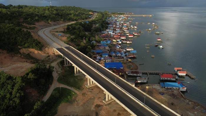 Foto udara beberapa kendaraan melintas di atas jembatan antara Kota Kendari dan Kecamatan Soropia di Kabupaten Konawe, Sulawesi Tenggara, Rabu (5/7/2023).  Pembangunan jalan dan jembatan sepanjang lebih 14 kilometer tersebut guna meningkatkan kegiatan di sektor perikanan dan pariwisata serta aktivitas perekonomian antara kabupaten-kabupaten yang menghubungkan ke pusat Kota Kendari. ANTARA FOTO/Jojon/aww.