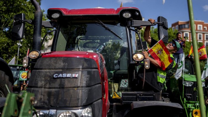Aksi Petani Konvoi Traktor di Jalanan Madrid, Serukan Bantuan Kekeringan Farmers drive their tractors during a protest on the streets of Madrid, Wednesday, July 5, 2023. Farmers arrive in tractors from around Spain to stage a protest demanding funds to alleviate problems caused by severe drought elevated production costs. (AP Photo/Manu Fernandez)