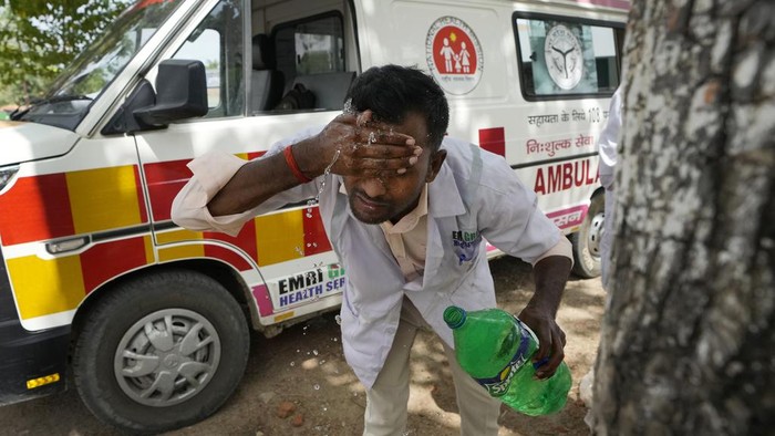 Duh, Pekan Ini Bumi Catat Rekor Hari Terpanas Sepanjang Sejarah Jitendra Kumar, a paramedic who travels in ambulance, washes his face with water to cool himself off after dropping a patient at Lalitpur district hospital, in Banpur, in Indian state of Uttar Pradesh, Saturday, June 17, 2023. (AP Photo/Rajesh Kumar Singh)