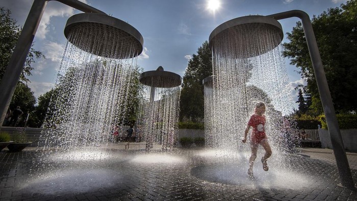 Duh, Pekan Ini Bumi Catat Rekor Hari Terpanas Sepanjang Sejarah A girl cools off in a public fountain in Vilnius, Lithuania, Wednesday, June 21, 2023. The heat wave continues in Lithuania as temperatures have been raising to as high as 32 degrees Celsius (89.6 degrees Fahrenheit). (AP Photo/Mindaugas Kulbis)