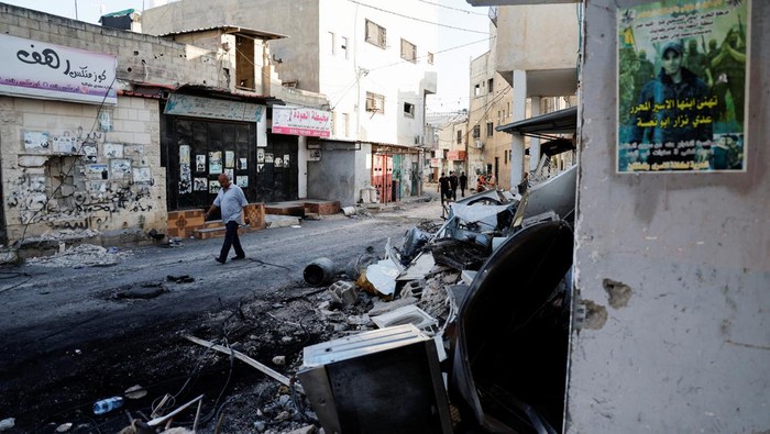 Jejak Serangan Israel di Jenin yang Tewaskan Belasan Warga Palestina Palestinians walk on the street after the Israeli army's withdrawal from the Jenin camp, in Jenin, in the Israeli-occupied West Bank July 5, 2023. REUTERS/Ammar Awad