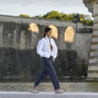 Desainer Valentino, Pierpaolo Piccioli, dibuka dengan penampilan model Kaia Gerber sebagai first face. Kaia yang terakhir kali eksis di catwalk akhir tahun lalu membuat comeback-nya terasa memukau dalam balutan blus putih dengan gaya braless setelah kancing bagian atas dibiarkan terbuka. (Foto: AP Photo/Christophe Ena)