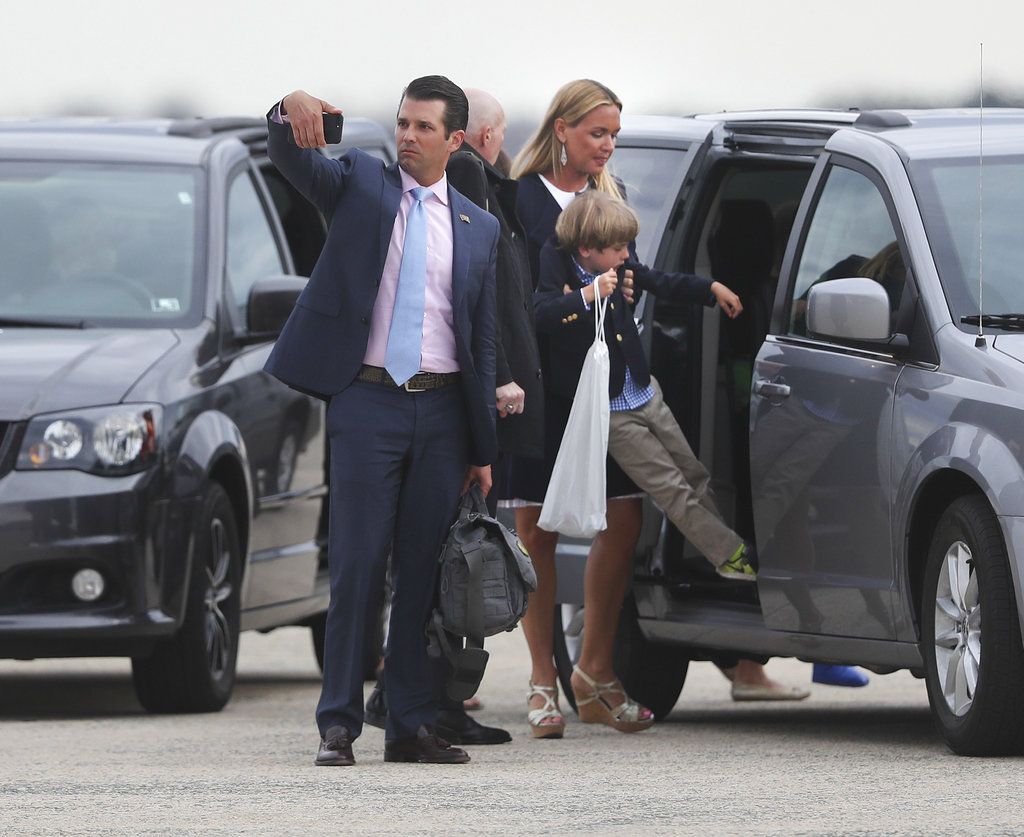 Donald Trump Jr. center, stops to take a photograph with his phone during his family's arrival at Andrews Air Force Base, Md., Sunday, April 1, 2018, as Vanessa Trump, center right, picks up their son Spencer to place him in the minivan. The Trump family was returning to Washington after spending Easter weekend at President Donald Trump's Mar-a-Lago estate in Palm Beach, Fla. (AP Photo/Pablo Martinez Monsivais)