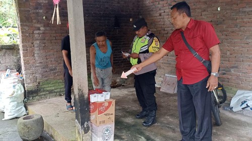 Petugas Polsek Marga melakukan indetifikasi di rumah I Made Rumada yang menjadi tempat kejadian perkara keracunan miras, Banjar Tegal, Desa Kukuh, Marga, Kamis (6/7/2023).
