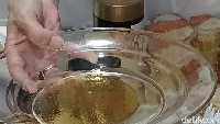 Cara lain, taruh madu di piring, kemudian dikasih air. Madu tidak akan bercampur dengan air. Bila piring diayak, madu tak larut dalam air tapi membentuk pola hexagonal seperti sarang lebah di dasar piring. Foto: (Nograhany WK/detikcom)