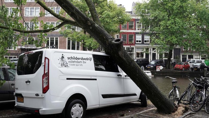 Mobil-mobil Ini Jadi Korban Pohon Tumbang di Amsterdam A fallen tree lies on a van after a storm hit Amsterdam, Netherlands July 5, 2023. REUTERS/Esther Verkaik