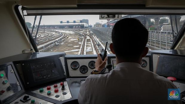 Pekerja memeriksa rangkaian gerbong (trainset) LRT Jabodebek yang terparkir di Depo LRT Jatimulya, Bekasi, Jawa Barat, Kamis (6/7/2023). (CNBC Indonesia/Faisal Rahman)