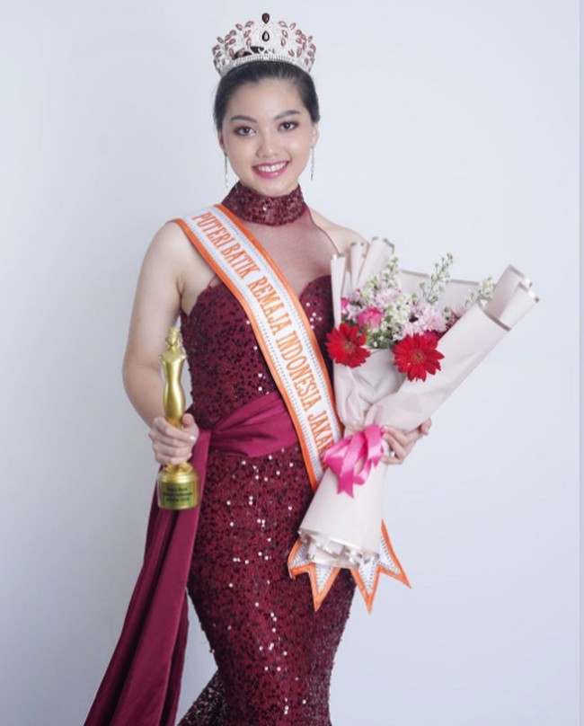 Ini potret Raihana Zemma Gunawan saat terpilih menjadi Putri Batik Remaja DKI Jakarta 2023. Ia tampak cantik dan anggun mengenakan gaun brokat merah. Foto: Instagram @officialputeriremajajakarta, @raihana_zemma
