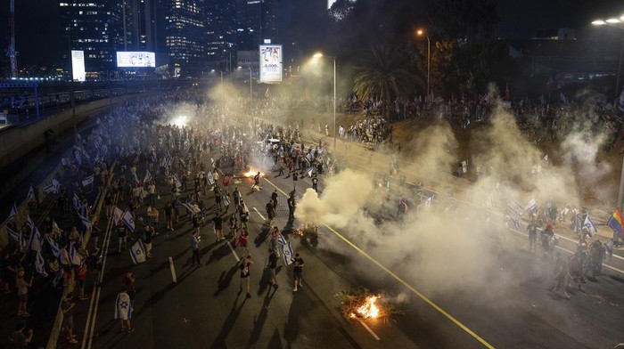 Israelis protest against plans by Prime Minister Benjamin Netanyahu's government to overhaul the judicial system, block the freeway in Tel Aviv, Israel, Wednesday, July 5, 2023. Thousands of protesters have blocked Tel Aviv's main highway and major intersections across Israel in a spontaneous outburst of anger following the ouster of the city's popular police chief. (AP Photo/Oded Balilty)