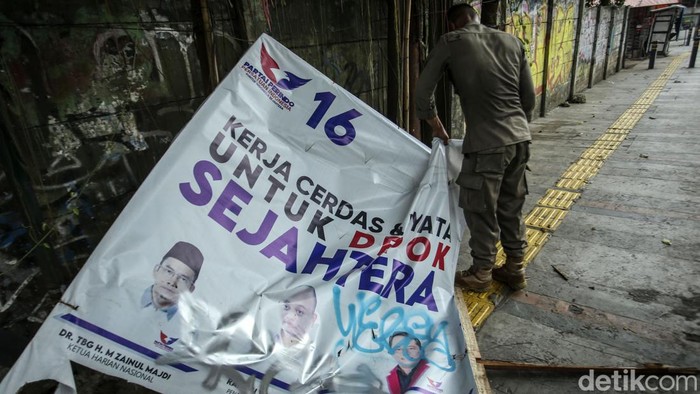 Satpol PP Tertibkan Atribut Partai di Depok Petugas Satpol PP dari Kelurahan Pancoran Mas menertibkan atribut partai politik di Depok, Kamis (6/7/2023).