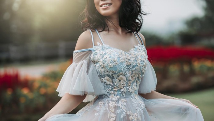 an asian chinese female model dress up with wedding gown for outdoor portrait session at public park in evening