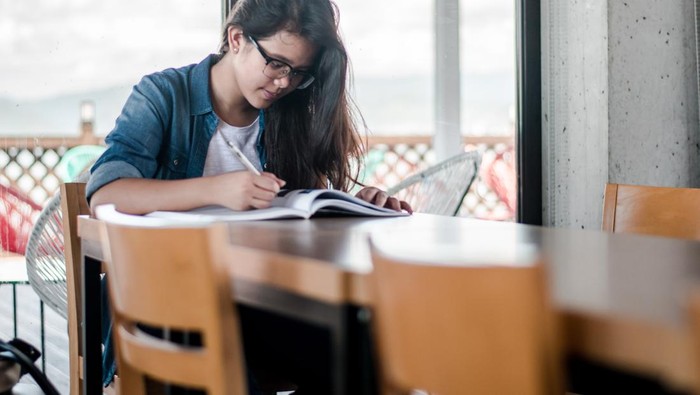 Anak atau siswa SMP SMA perempuan sedang belajar