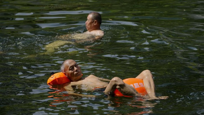 Cara Warga Beijing Hadapi Cuaca Panas Menyengat Residents cool off from a sweltering day at an urban waterway in Beijing, Thursday, July 6, 2023. Employers in Beijing were ordered Thursday by the government to stop outdoor work after scorching summer heat in the Chinese capital was forecast to reach 40 degrees centigrade (104 Fahrenheit). (AP Photo/Andy Wong)
