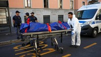 Petugas mengevakuasi jenazah korban di tempat kejadian setelah kebakaran di rumah jompo di Milan, Italia, Jumat (7/7/2023).