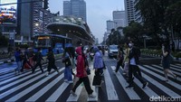 Sejumlah pekerja beraktivitas di pelican crossing, Jalan Jenderal Sudirman, Jakarta, Jumat (7/7/2023).  