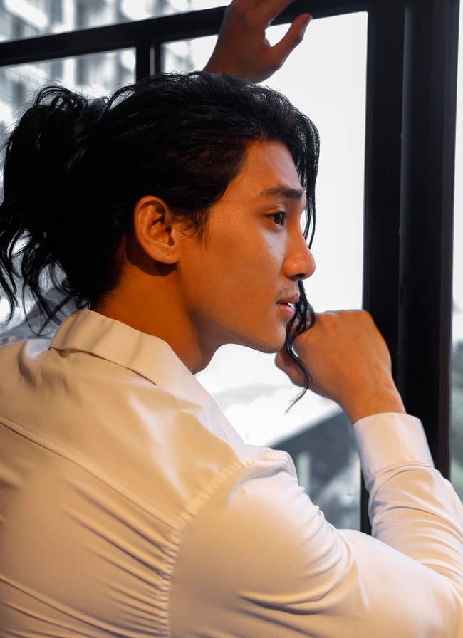 Dalam pemotretan yang dijalaninya, Pain Takhon didandani dengan rambut tambahan sehingga dia terlihat berambut gondrong. Rambutnya ditata dikuncir dengan menyisakan beberapa helai di bagian depan. Foto: Dok. Instagram Paing Takhon