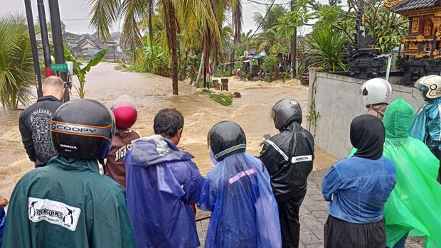 Warga Perumahan Griya Multi, Tabanan, tidak bisa menuju rumah mereka karena banjir pada Jumat (7/7/2023).