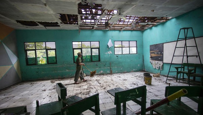 Petugas sekolah membersihkan ruang kelas yang rusak terdampak puting beliung di Madrasah Tsanawiyah (MTs) Negeri 8 Indramayu, Jawa Barat, Jumat (7/7/2023). Menurut data BPBD Indramayu, sebanyak dua ruang kelas di sekolah tersebut rusak akibat diterjang angin puting beliung pada Kamis (6/7) sore. NTARA FOTO/Dedhez Anggara/foc.