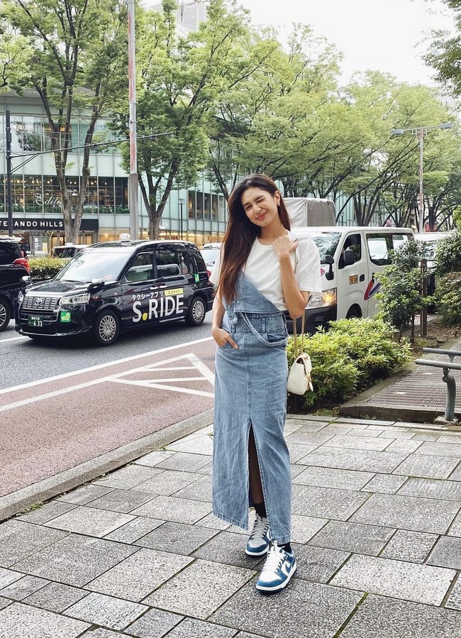 Mikha Tambayong tampil dengan vibe girl next door lewat pinafore dress berbahan denim yang dipadukan t-shirt putih. Tak lupa sneakers untuk semakin menonjolkan street fashion. Foto: Instagram/@miktambayong
