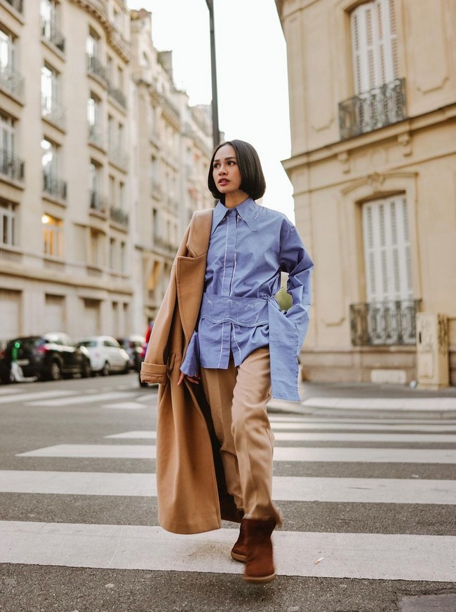 Andien dikenal sebagai artis yang berani mix ’n match busana sehingga terlihat unik. Seperti gaya stylish yang ditampilkannya saat memadukan kemeja oversized, celana chino, trench coat dan boots. Foto: Instagram/@andienaisyah