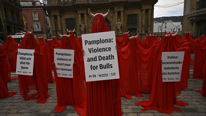 Warga di Spanyol Protes Kekejaman Terhadap Hewan Jelang Festival San Fermin People covered with San Fermin's red color protest against animal cruelty before the start of the San Fermin festival at Plaza del Ayuntamiento square in Pamplona, northern Spain, Wednesday, July 5, 2023. On July 6th, the San Fermin festival will begin and last for nine days where thousands of people will take part in the famous running of the bulls through the old streets of the city. (AP Photo/Alvaro Barrientos)