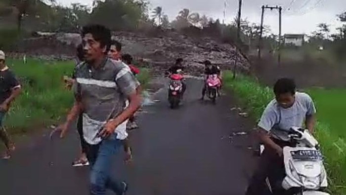 Warga kalang kabut berlarian menyelamatkan diri saat banjir lahar dingin meluap dari sungai.