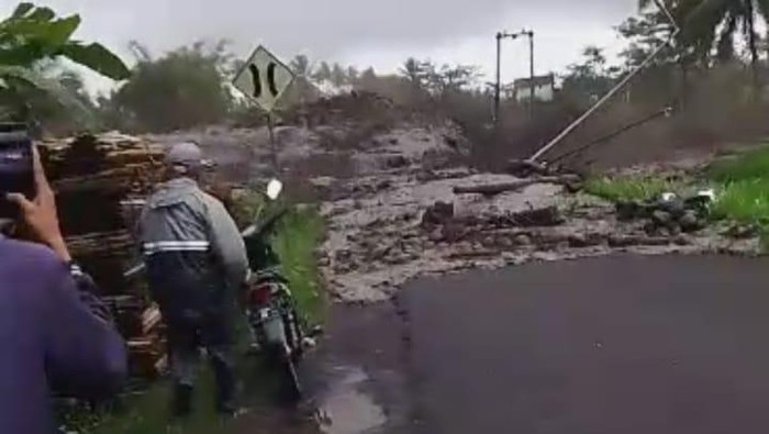 Warga kalang kabut berlarian menyelamatkan diri saat banjir lahar dingin meluap dari sungai.