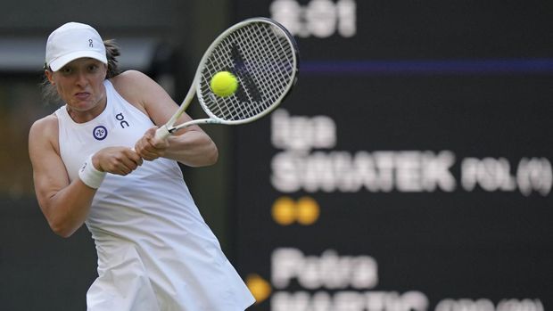 Poland's Iga Swiatek returns to Croatia's Petra Martic in a women's singles match on day five of the Wimbledon tennis championships in London, Friday, July 7, 2023. (AP Photo/Alberto Pezzali)