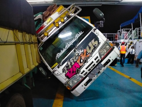 Kendaraan truk yang roboh di atas kapal saat pelayaran di Selat Bali akibat gelombang tinggi dan menimpa kendaraan lainnya, Jumat (8/7/2023). (Istimewa)