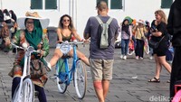 Ada juga wisman yang asyik foto-foto di atas sepeda onthel. 
