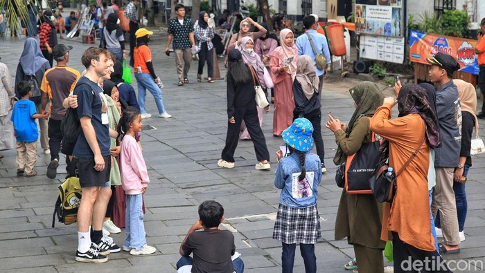 Mengejar Target Wisman 8,5 Juta Orang di Tahun 2023 Para wisatawan mancanegara (wisman) berfoto bersama wisatawan lokal di kawasan Kota Tua, Jakarta Barat, Sabtu (8/7/2023). Pemerintah optimis target kunjungan wisman 8,5 juta orang akan tercapai di tahun ini. Salah satu indikatornya yakni angka kunjungan wisatawan naik di kuartal pertama 2023.
