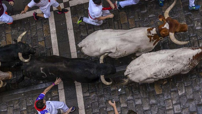 People wait for the start the third day of the running of the bulls from balconies during the San Fermin fiestas in Pamplona, Spain, Sunday, July 9, 2023. (AP Photo/Alvaro Barrientos)