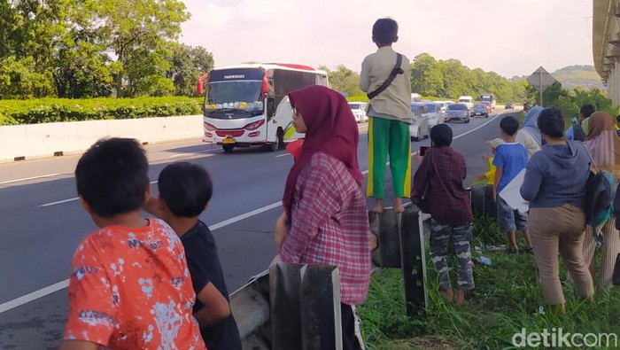 Bocah Hingga Orang Dewasa Berburu Om Telolet Om di Pinggir Jalan Tol Cipularang