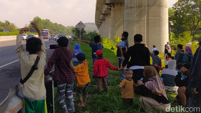 Bocah Hingga Orang Dewasa Berburu Om Telolet Om di Pinggir Jalan Tol Cipularang