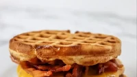 Sengaja disajikan sebagai menu sarapan, burger ini mengganti bun dengan waffle. Tetapi di dalamnya tetap dilengkapi dua buah patty dan saus keju yang melimpah. Foto: Crazy and Co