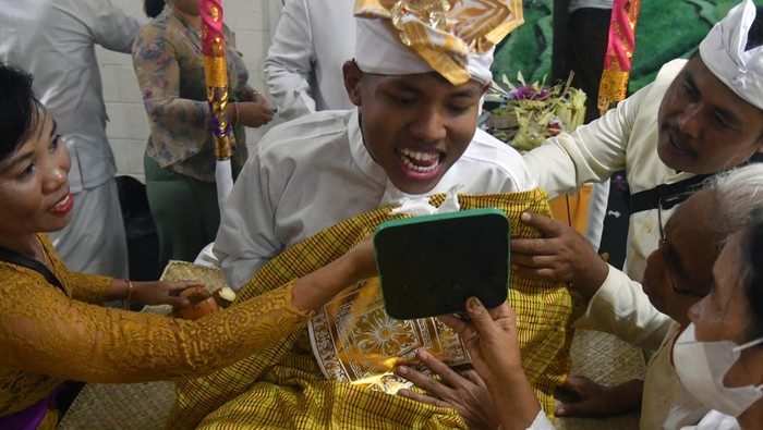 Seorang remaja mengikuti prosesi potong gigi (Mepandes) Banjar Suka Duka Hindu Dharma Bogor 2023 di Pasraman Pura Giri Kusuma, Kota Bogor, Jawa Barat, Minggu (9/7/2023). Prosesi potong gigi yang diikuti 70 remaja umat Hindu itu bertujuan menyeimbangkan kehidupan dengan menghilangkan enam sifat buruk dalam diri manusia serta sebagai simbol memasuki usia dewasa. ANTARA FOTO/Arif Firmansyah/Spt.