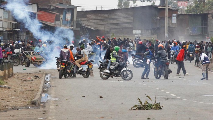 Supporters of Kenya's opposition leader Raila Odinga of the Azimio La Umoja (Declaration of Unity) One Kenya Alliance, run after riot police officers lobbed tear gas to disperse them during an anti-government protest dubbed 