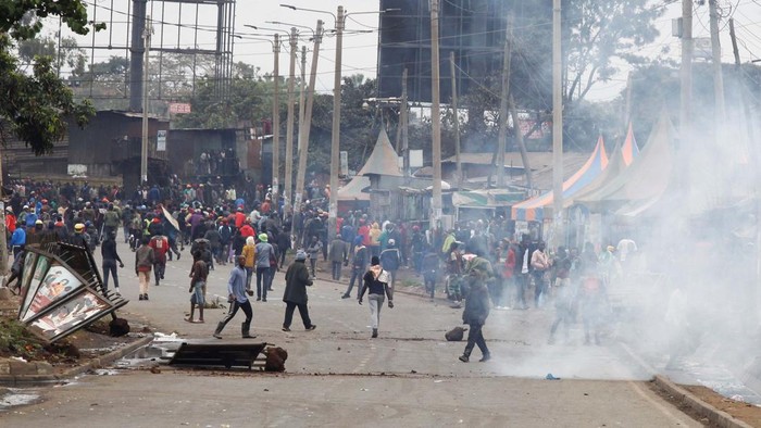 Protes Kenaikan Pajak di Kenya Ricuh, 3 Orang Tewas Supporters of Kenya's opposition leader Raila Odinga of the Azimio La Umoja (Declaration of Unity) One Kenya Alliance, run after riot police officers lobbed tear gas to disperse them during an anti-government protest dubbed
