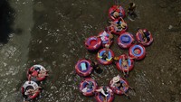 Umbi mengapung di Sungai Comal yang sejuk di New Braunfels, Texas. Rekor global ini merupakan indikasi lain tentang seberapa cepat dunia memanas, karena kedatangan fenomena iklim alami El Niño, yang memiliki efek pemanasan, berlapis di atas pemanasan global yang dipicu oleh perubahan iklim. AP/Eric Gay  