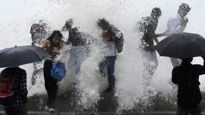Beragam Aksi Warga di Berbagai Negara Hadapi Panas Ekstrem People enjoy high tide waves on the Arabian Sea coast in Mumbai, India, Thursday, July 6, 2023.(AP Photo/Rajanish Kakade)