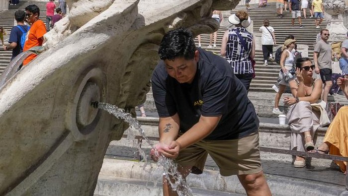 Cuaca Panas Hebat Melanda Italia, Bikin Warga Kehausan A man refreshes at the Baroque-style fountain 'Fontana della barcaccia' at the foot of the Spanish Steps in Rome's Piazza di Spagna Wednesday, June 21, 2023. With around 34 Celsius (93F) degrees today in Rome, temperatures in Italy are rapidly reaching summer averages with peaks expected for tomorrow of up to 40 degrees Celsius in Rome. (AP Photo/Andrew Medichini)