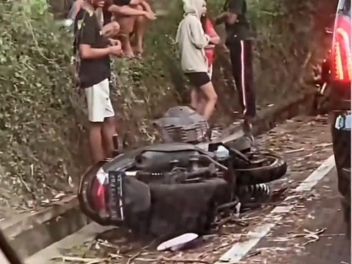 Motor yang digunakan oleh dua perempuan tergeletak setelah tertabrak bus di jalan Denpasar-Singaraja, Desa Sembung, Badung, Minggu (9/7/2023).