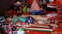 Seorang pengungsi yang sedang sakit terbaring di dalam tenda.  